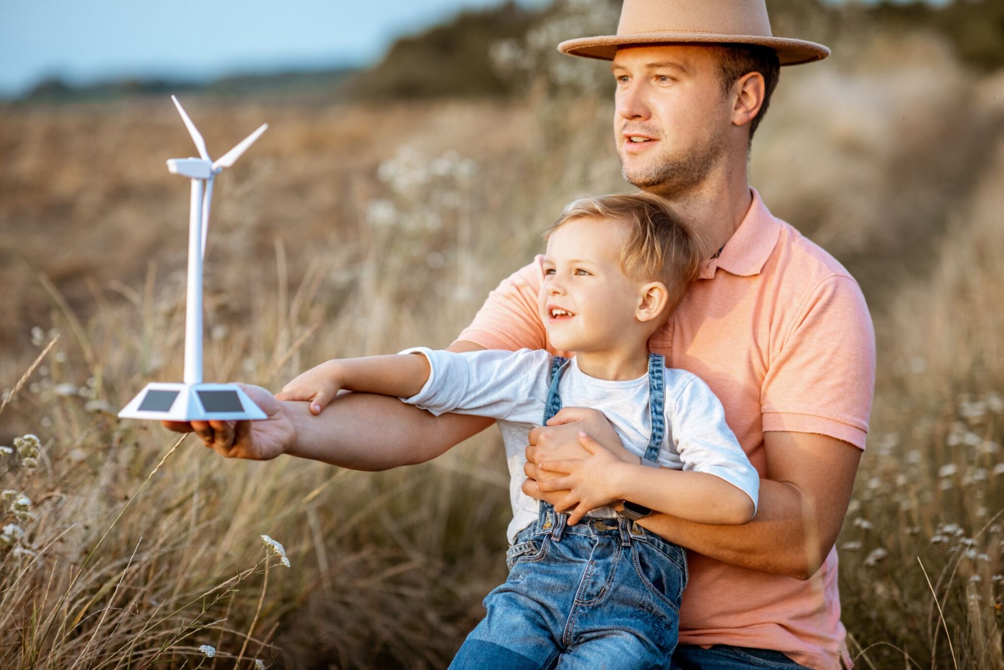 Father and young son playing with wind turbine